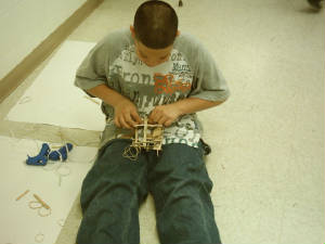 Sixth grade boy building his catapult.